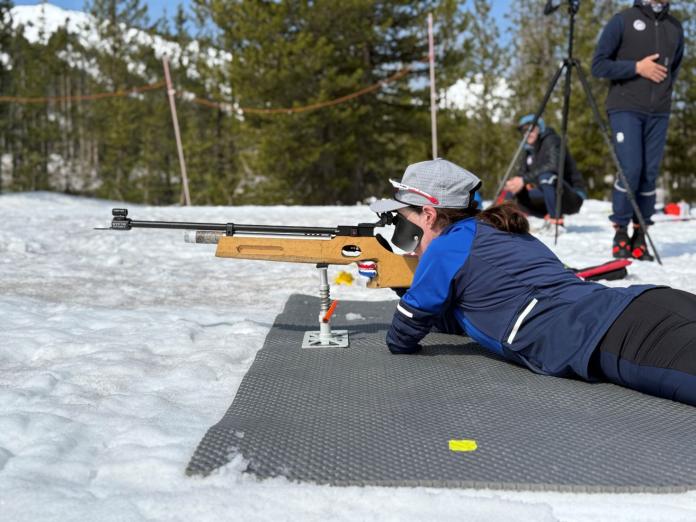 A female athlete is training on the rifle